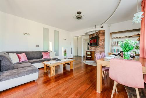 una sala de estar con un sofá y una mesa en Lumina luxury apart with jaccuzi on Sienkiewicza street, en Łódź