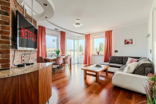 ein Wohnzimmer mit Sofa und Fernseher in der Unterkunft Lumina luxury apart with jaccuzi next to Piotrkowska Street in Łódź
