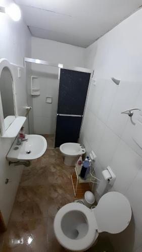 a white bathroom with a toilet and a sink at Los Nietos in La Paloma
