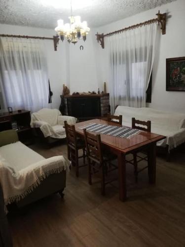 a living room with a wooden table and chairs at Παραδοσιακο σπιτι με εσωτερικο τζακι in Chrysomiléa