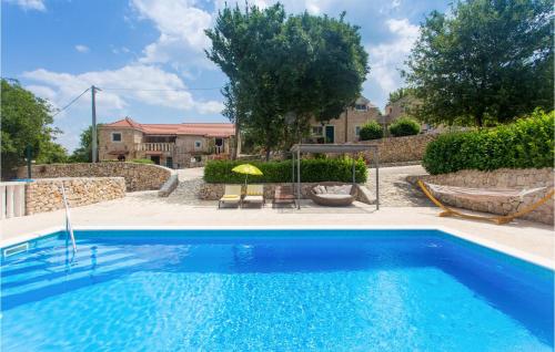 a blue swimming pool in a yard with a building at Seven-Bedroom Holiday Home In Dicmo in Osoje