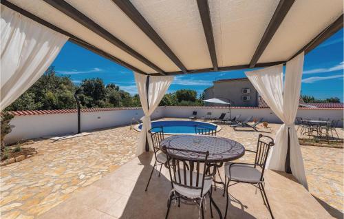 eine Terrasse mit Tisch und Stühlen und einem Pool in der Unterkunft Gorgeous Home In Pakostane With Kitchen in Pakoštane