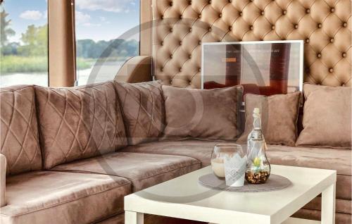a living room with a brown couch and a white table at Awesome Ship In Neuruppin With Kitchen in Neuruppin
