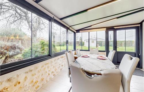 une salle à manger avec une table, des chaises et des fenêtres dans l'établissement Nice Home In Meschers-Sur-Gironde, à Meschers-sur-Gironde