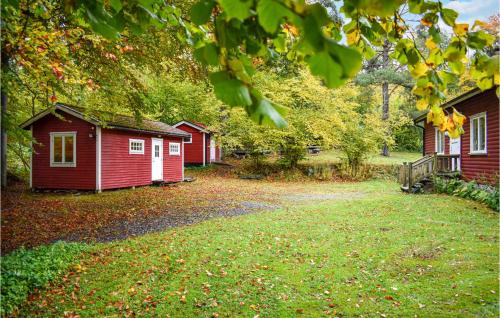 a row of small red buildings in a yard at Nice Home In Tormestorp With Lake View in Tormestorp