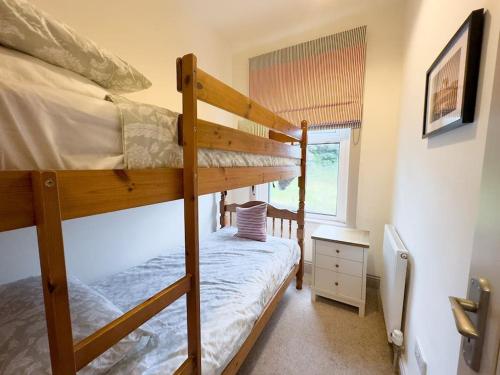 a bedroom with two bunk beds and a window at RIDGEMOUNT APT - Great base for walking and cycling in Keswick, Lake District National Park in Keswick