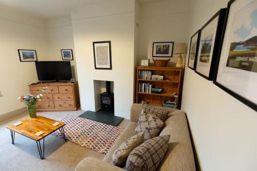 a living room with a couch and a tv at RIDGEMOUNT APT - Great base for walking and cycling in Keswick, Lake District National Park in Keswick