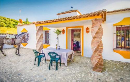 ein Pferd steht vor einem Haus mit einem Tisch und Stühlen in der Unterkunft 5 Bedroom Awesome Home In Ubrique in Ubrique