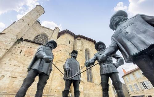 a statue of three men pulling a rope in front of a building at Lovely Apartment In Mauléon D'armagnac in Mauléon-dʼArmagnac