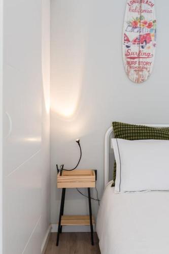 a bedroom with a bed and a night stand next to a table at Oporto Seaside Village - Casa Praia in Matosinhos