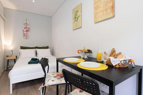 a dining room with a table and a bed at Oporto Seaside Village - Casa Praia in Matosinhos