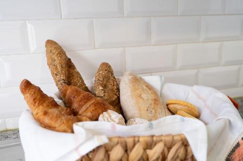 a basket of different types of bread and pastries at Oporto Seaside Village - Casa Praia in Matosinhos