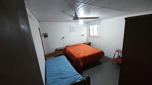 een kleine kamer met een bed en een plafondventilator bij Los Nietos in La Paloma