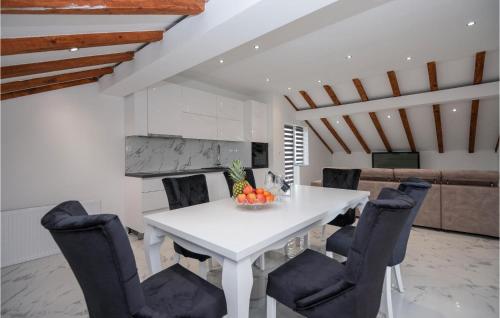 a dining room with a white table and chairs at Lovely Home In Podbablje Gornje in Podbablje