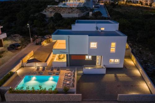 an aerial view of a house with a swimming pool at Villa Domenica - Luxury Apartment with Pool, Hot Tub & Sea View in Novalja