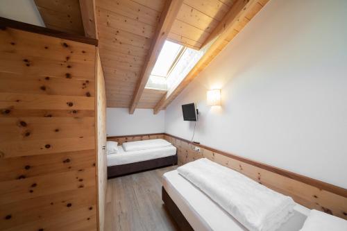 a bedroom with two beds and a skylight at Ansitz Velseck-Residence Hotel in Tires