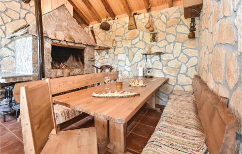 a wooden table in a room with a stone wall at Cozy Home In Vojnic Sinjski With Sauna in Vojnić Sinjski
