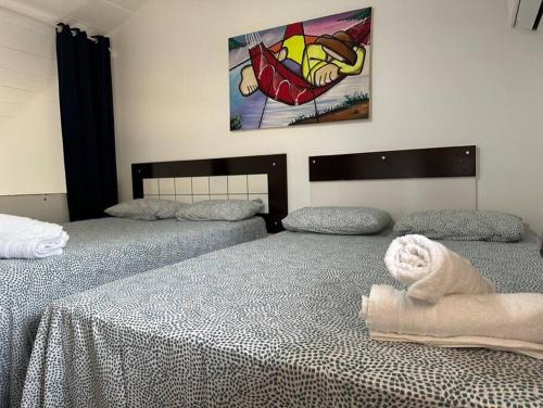 two beds sitting next to each other in a bedroom at Duplex Arembepe, beira mar, piscina i wifi in Camaçari