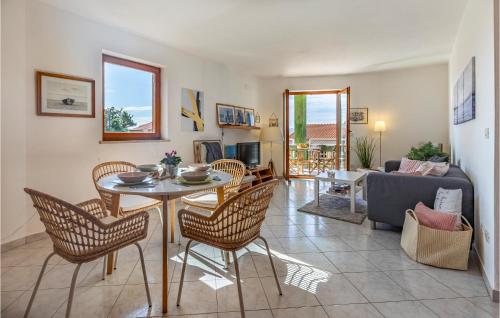ラバックにあるAmazing Apartment In Rabac With Wifiのテーブルと椅子とソファのあるリビングルーム