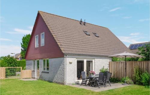 a small house with a table and chairs in a yard at Oesterbaai -5C2 in Wemeldinge