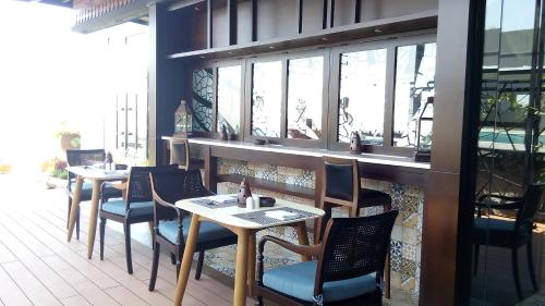 a restaurant with two tables and chairs and windows at Swiss-Belinn Saripetojo Solo in Solo