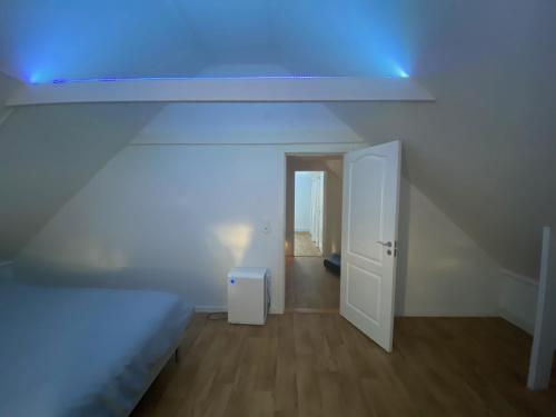 a white room with a bed and a blue light at Sjöutsikt, Röd trästuga med traditionellt yttre Skandinavisk, modernt inre och alla bekvämligheter, Sol hela dagen på stora altanen, Tryggt, Vinterbonat, Fiske, Båt in Skinnskatteberg