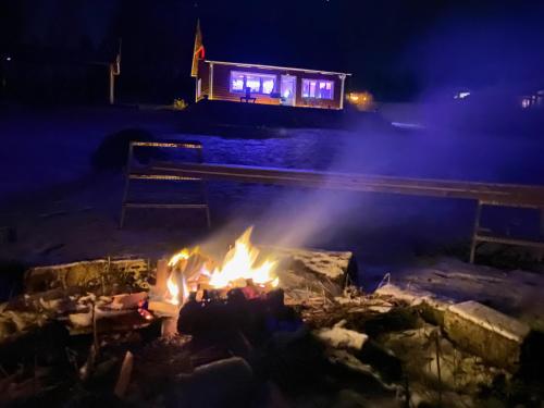 a fire pit at night with a building in the background at Sjöutsikt, Röd trästuga med traditionellt yttre Skandinavisk, modernt inre och alla bekvämligheter, Sol hela dagen på stora altanen, Tryggt, Vinterbonat, Fiske, Båt in Skinnskatteberg