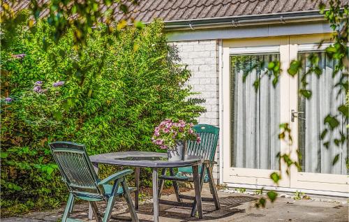 a table with two chairs and a vase of flowers on it at Oesterbaai -5C1 in Wemeldinge