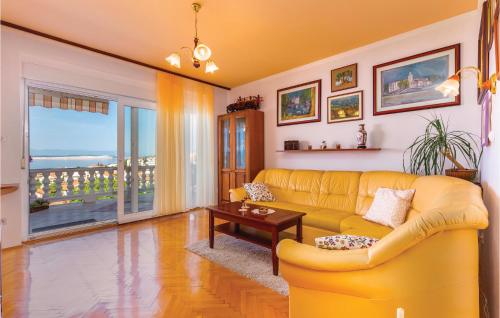a living room with a yellow couch and a table at Cozy Apartment In Crikvenica in Crikvenica