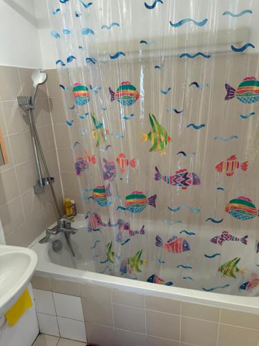 La salle de bains est pourvue d'un rideau de douche avec des poissons. dans l'établissement Piso en paris metro duplex Line 6, à Paris