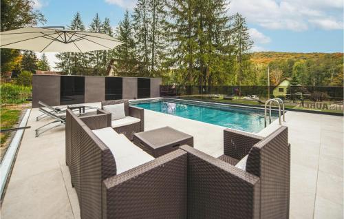a swimming pool with chairs and an umbrella at Lovely Home In Novo Zvecevo With Sauna in Novo Zvecevo