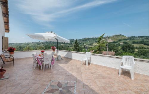 a patio with a table and chairs and an umbrella at Nice Home In Castelnuovo Di Farfa in Castelnuovo di Farfa