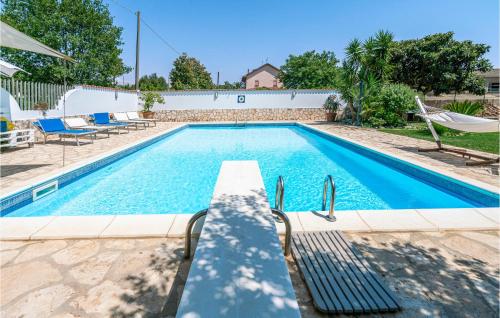 a pool with a chair and a hammock in a house at 2 Bedroom Cozy Home In Sabaudia in Sabaudia