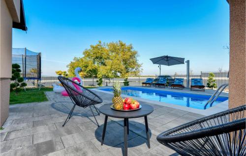 un patio con tavolo e sedie e una piscina di Awesome Home In Gracec With Sauna a Gračec