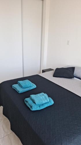 two blue towels are sitting on a black bed at Torre Charlotte in Posadas
