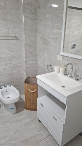 a white bathroom with a sink and a toilet at Torre Charlotte in Posadas