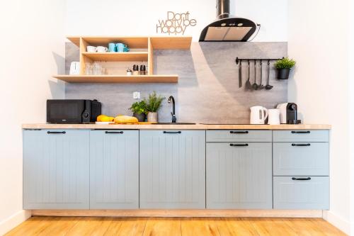 a kitchen with white cabinets and a counter top at Marina Luna - widok na jezioro, parking podziemny, winda, Netflix, Max in Iława