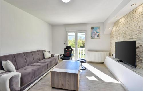 a living room with a couch and a tv at Lovely Home In Stikada With Sauna in Štikada