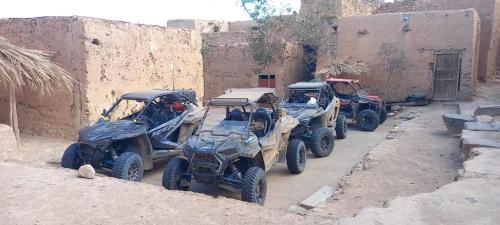 a group of four four wheelers parked next to a building at Maison d'hôte sirwaji in Assa