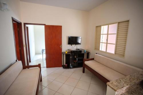 a living room with a couch and a television at Casa em Baependi-Até 7 pessoas in Baependi