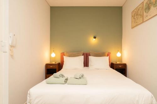 a bedroom with a white bed with two towels on it at Oporto Seside Village - Casa Mar in Matosinhos