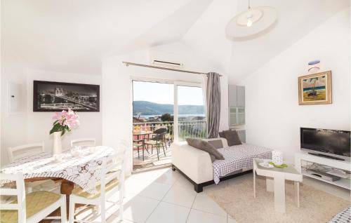 a living room with a couch and a table and a television at Nice Apartment In Poljica in Poljica