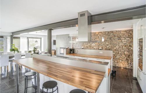 a kitchen with a wooden counter and a stone wall at Les Brumes in Manhay