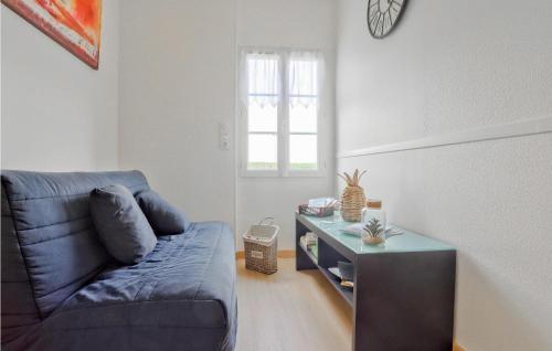 a living room with a blue couch and a table at Gorgeous Home In Creances-Plage in Créances