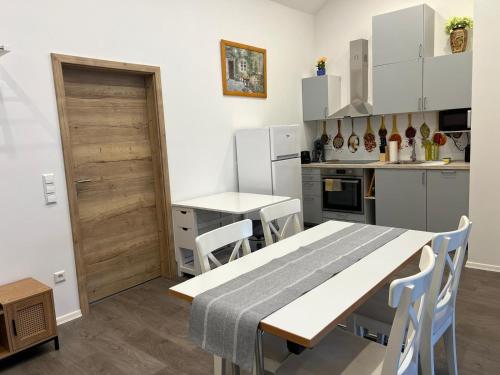 a kitchen with a table and chairs in a room at VipStay - Stilvoll und geräumige Apartments mit Terasse oder Balkon, Küche, kostenloses Parken, WLAN, Smart Tv in Wiesloch