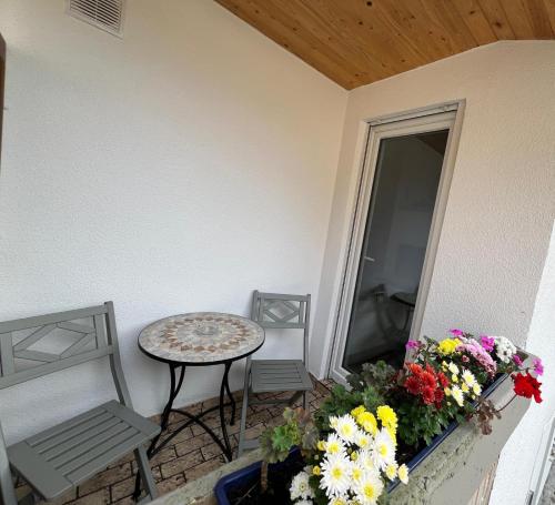 a patio with a table and chairs and flowers at VipStay - Stilvoll und geräumige Apartments mit Terasse oder Balkon, Küche, kostenloses Parken, WLAN, Smart Tv in Wiesloch
