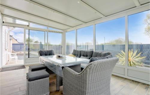 a dining room with a table and chairs and windows at Gorgeous Home In Creances-Plage in Créances