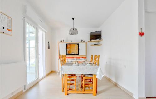 a dining room with a table and chairs at Gorgeous Home In Creances-Plage in Créances