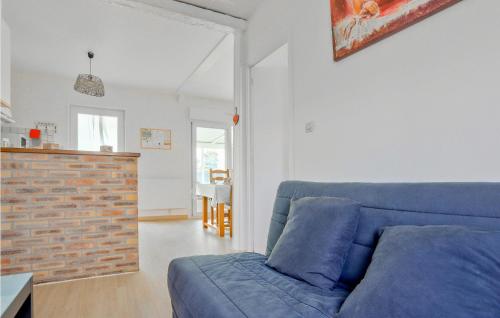 a living room with a blue couch and a brick wall at Gorgeous Home In Creances-Plage in Créances
