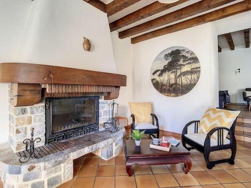 a living room with a stone fireplace and chairs at Gîte Le Karrdi in Landavran